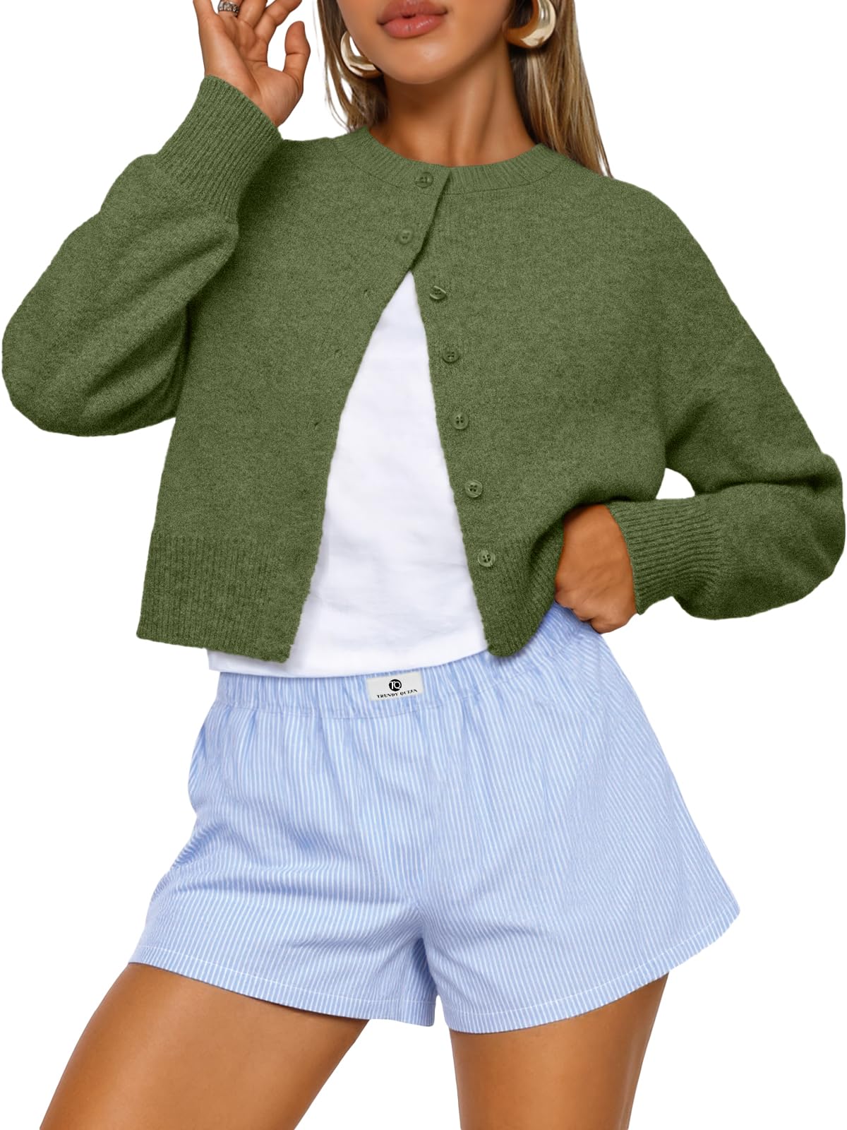 Model pairing the cropped cardigan with a skirt for a layered fall outfit